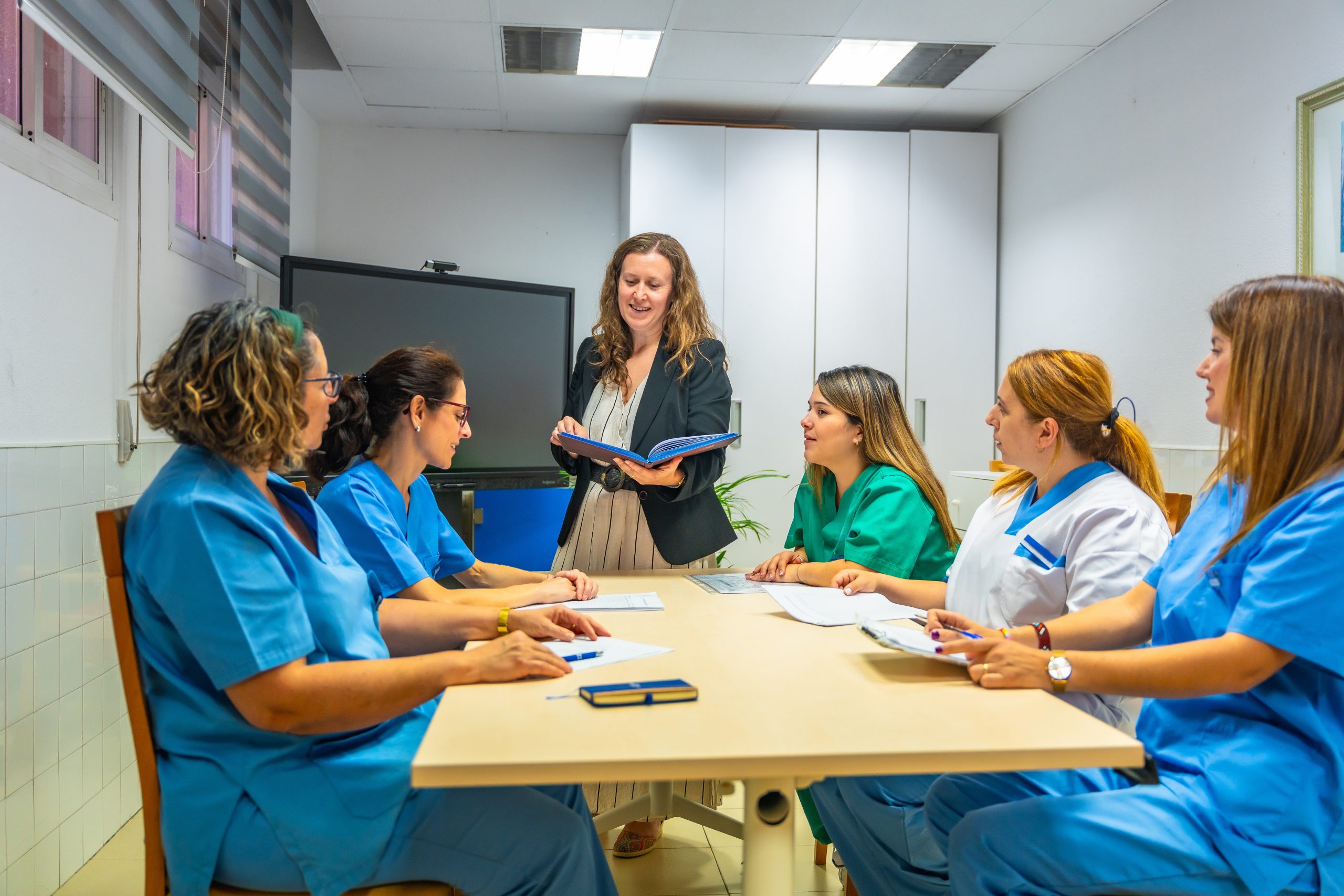 Photo of a medical staff meeting with nurses and leadership team.