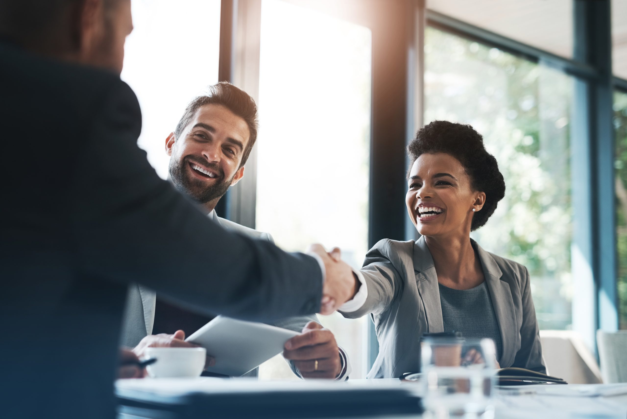 Photo of people shaking hands in business deal completion.